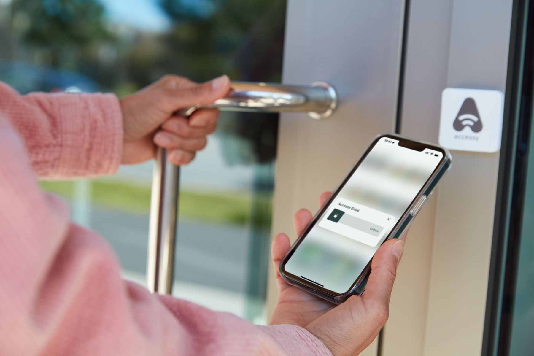 A person using the Accessy app to open the front door to a office building
